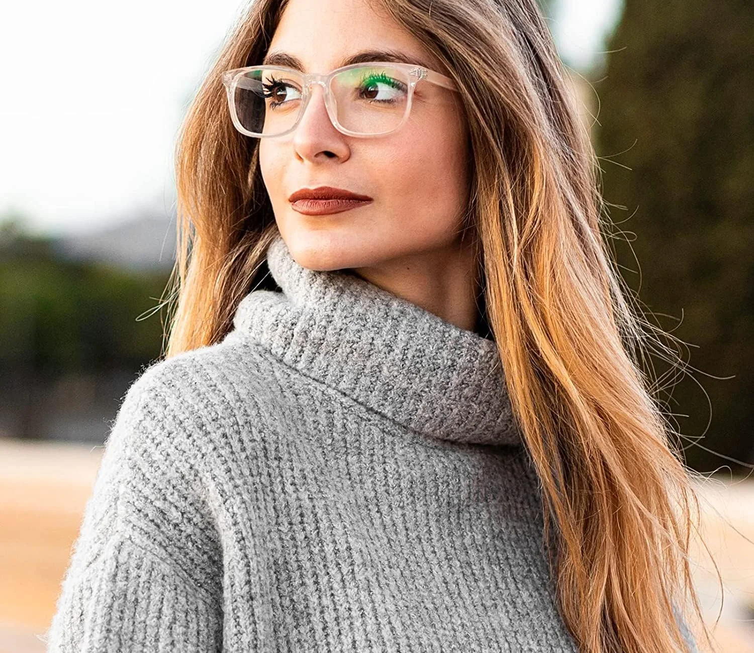 A woman in a transparent GQUEEN square clear-lens frame and a grey roll-neck jumper